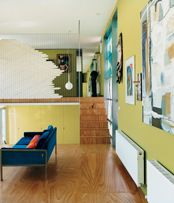 Идея дизайна: двухуровневая гостиная комната среднего размера в современном стиле с зелеными стенами и полом из фанеры без камина, телевизора
