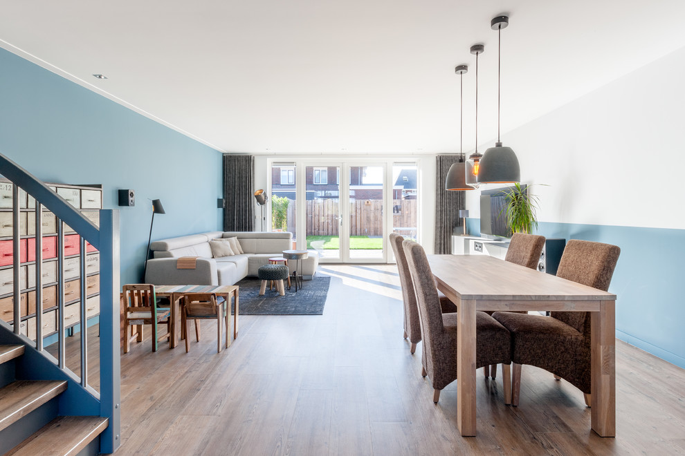 Offenes Stilmix Wohnzimmer mit blauer Wandfarbe und TV-Wand in Amsterdam