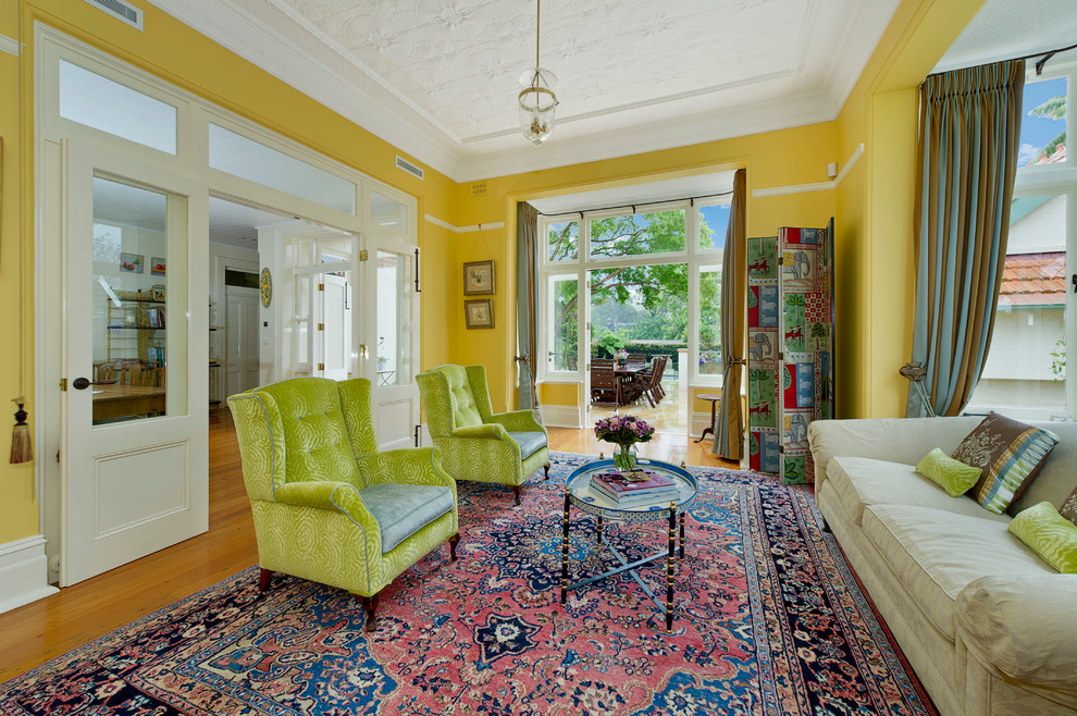 Ispirazione per un soggiorno tradizionale di medie dimensioni e chiuso con pareti gialle, pavimento in legno massello medio e pavimento marrone