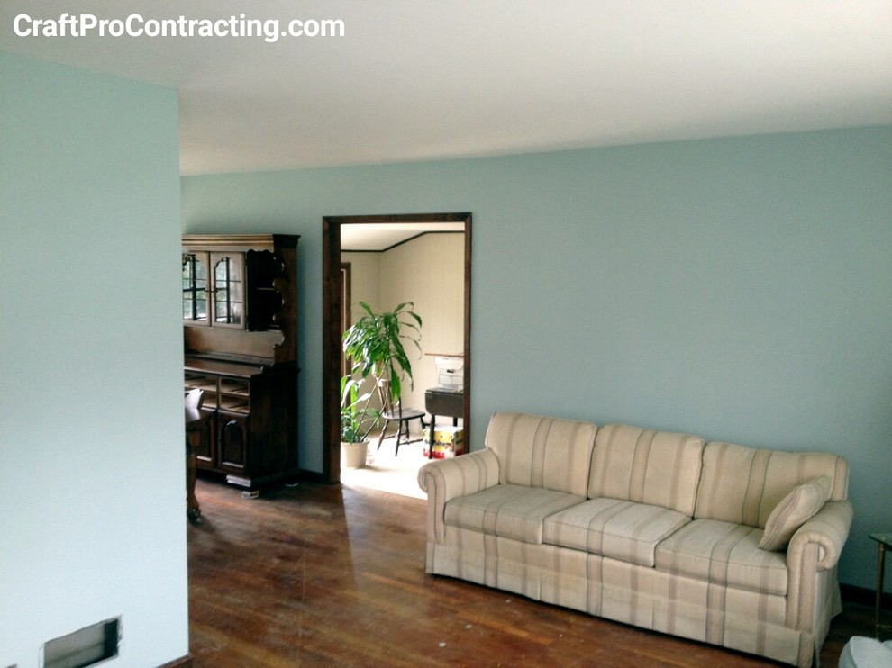 Exemple d'un salon chic de taille moyenne et ouvert avec un mur bleu et un sol en bois brun.