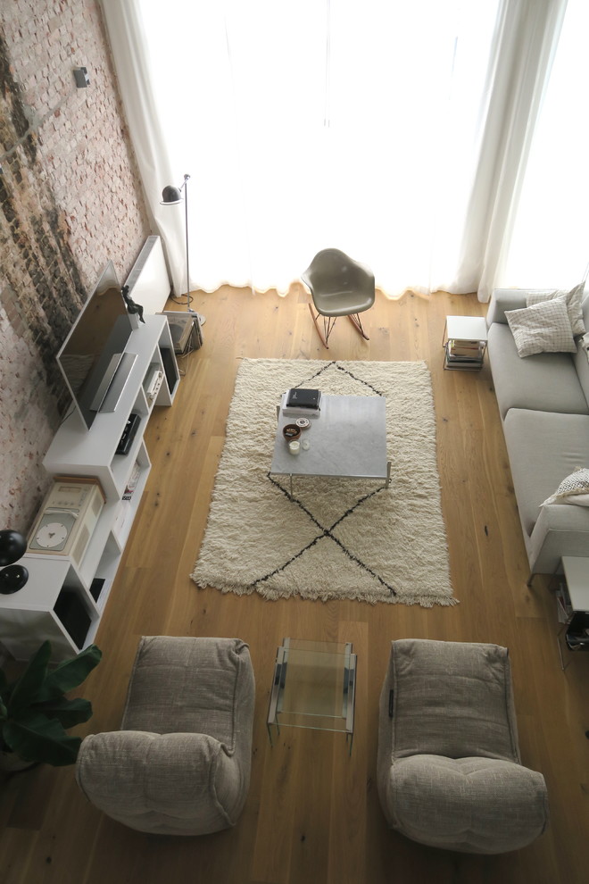 Пример оригинального дизайна: открытая гостиная комната среднего размера в стиле лофт с домашним баром, разноцветными стенами, светлым паркетным полом, отдельно стоящим телевизором и коричневым полом без камина