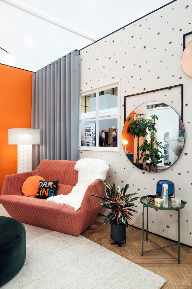 Idée de décoration pour un salon design avec un mur orange, un sol en vinyl et un sol marron.