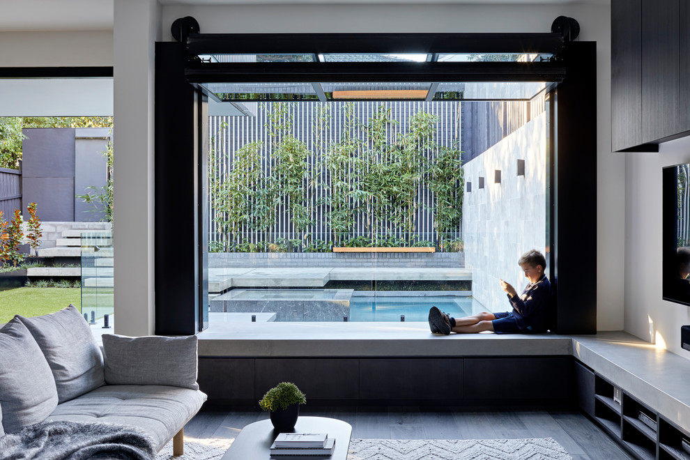 Idee per un soggiorno design con pareti bianche, parquet scuro, TV a parete e pavimento grigio