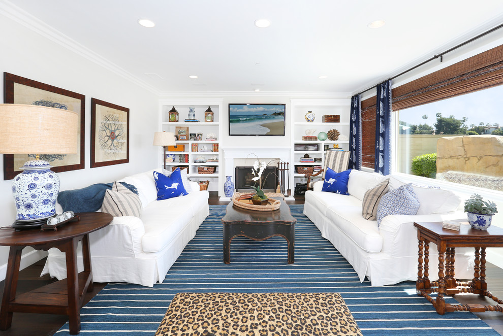 This is an example of a beach style formal living room in Orange County with white walls, a standard fireplace and no tv.
