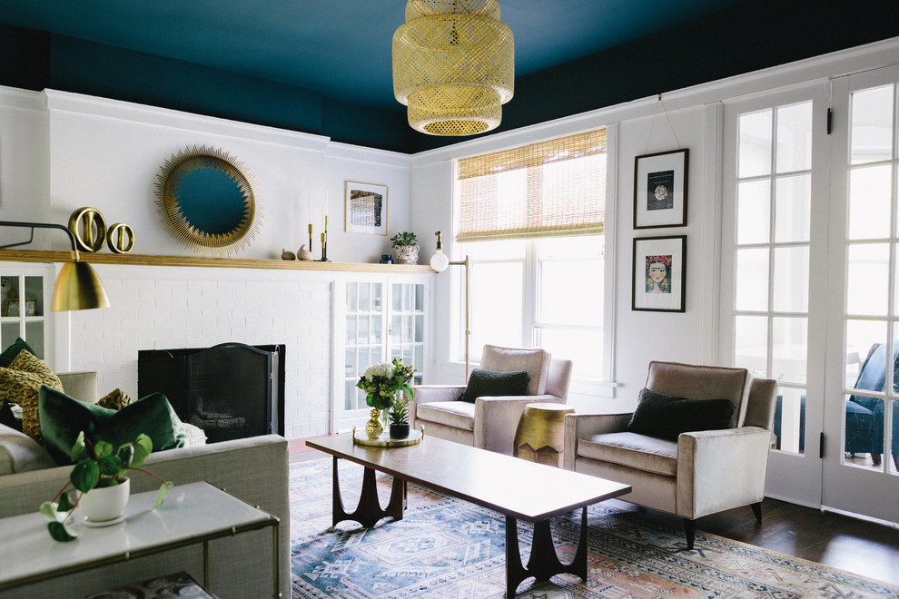 Пример оригинального дизайна: гостиная комната среднего размера в стиле неоклассика (современная классика) с белыми стенами, стандартным камином, коричневым полом, темным паркетным полом и фасадом камина из кирпича