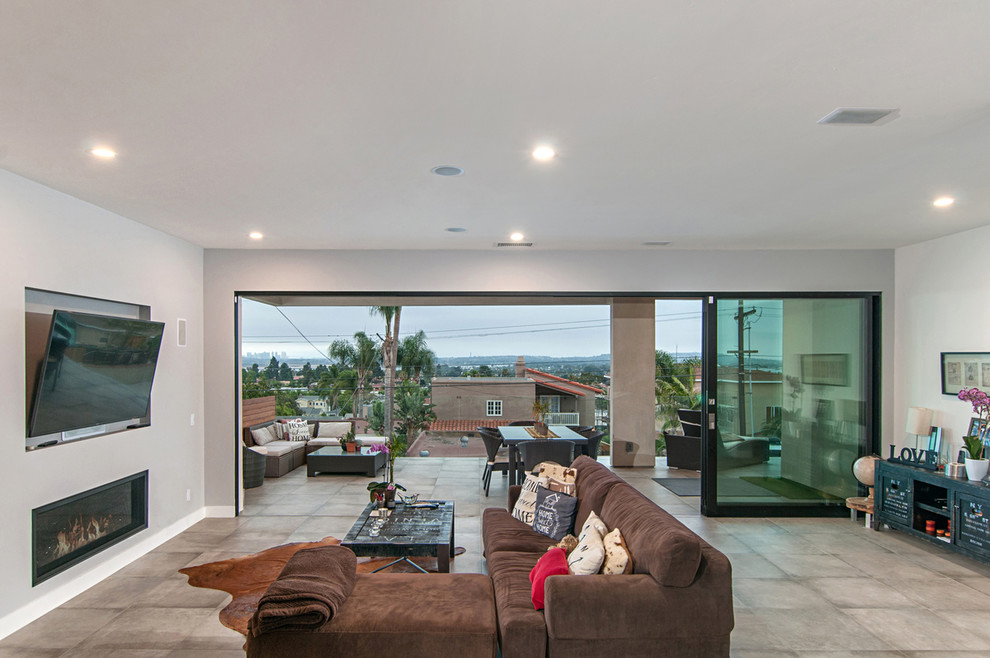 Mid-sized minimalist open concept concrete floor and gray floor living room photo in San Diego with gray walls, a ribbon fireplace, a metal fireplace and a wall-mounted tv
