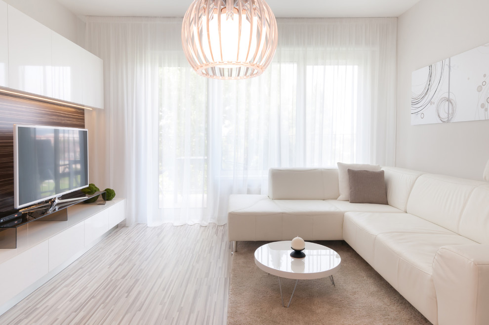 Стильный дизайн: изолированная гостиная комната среднего размера в стиле модернизм с белыми стенами и отдельно стоящим телевизором - последний тренд