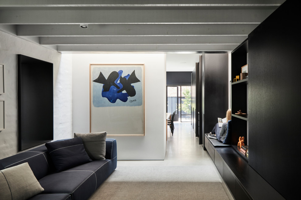 Ispirazione per un soggiorno design aperto con pareti bianche, pavimento in cemento, TV nascosta e pavimento grigio