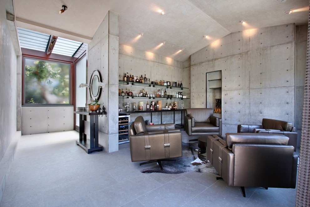 Foto de salón con barra de bar abierto minimalista de tamaño medio con paredes grises, todas las chimeneas y marco de chimenea de hormigón