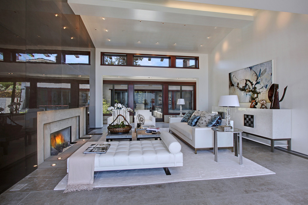 Photo of a large modern open plan living room in Los Angeles with white walls, a standard fireplace and a concrete fireplace surround.