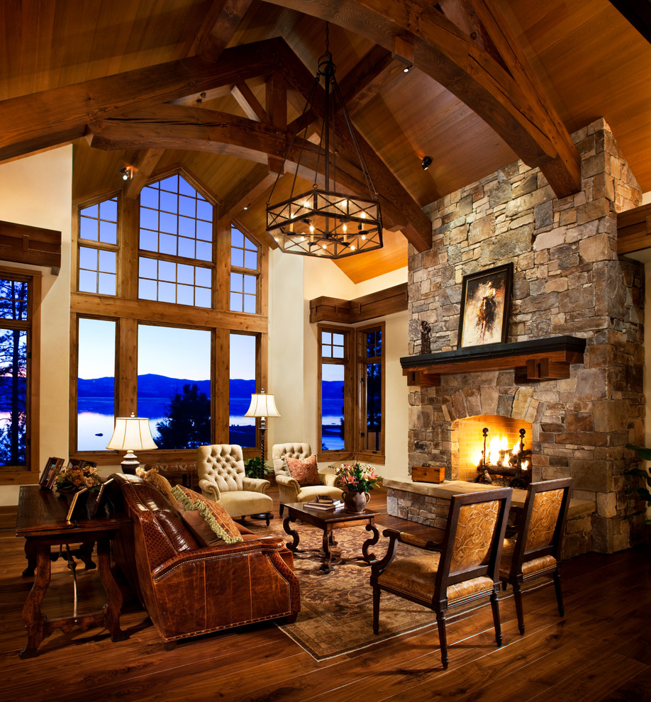 Example of a large classic formal and loft-style medium tone wood floor living room design in Orange County with beige walls, a standard fireplace, a stone fireplace and no tv