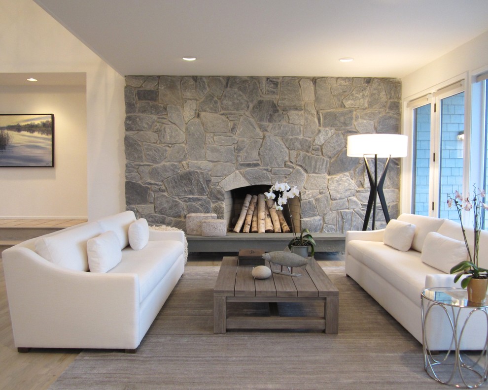 Example of a mid-sized beach style formal and open concept light wood floor living room design in New York with beige walls, a standard fireplace and a stone fireplace