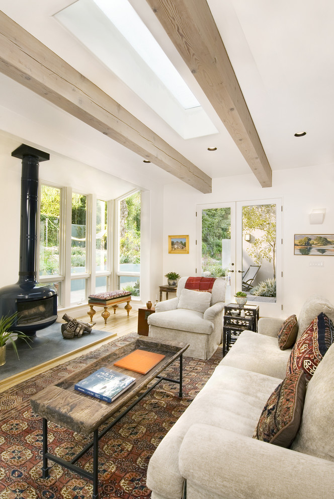 Idee per un soggiorno classico aperto e di medie dimensioni con pareti bianche, stufa a legna e parquet chiaro