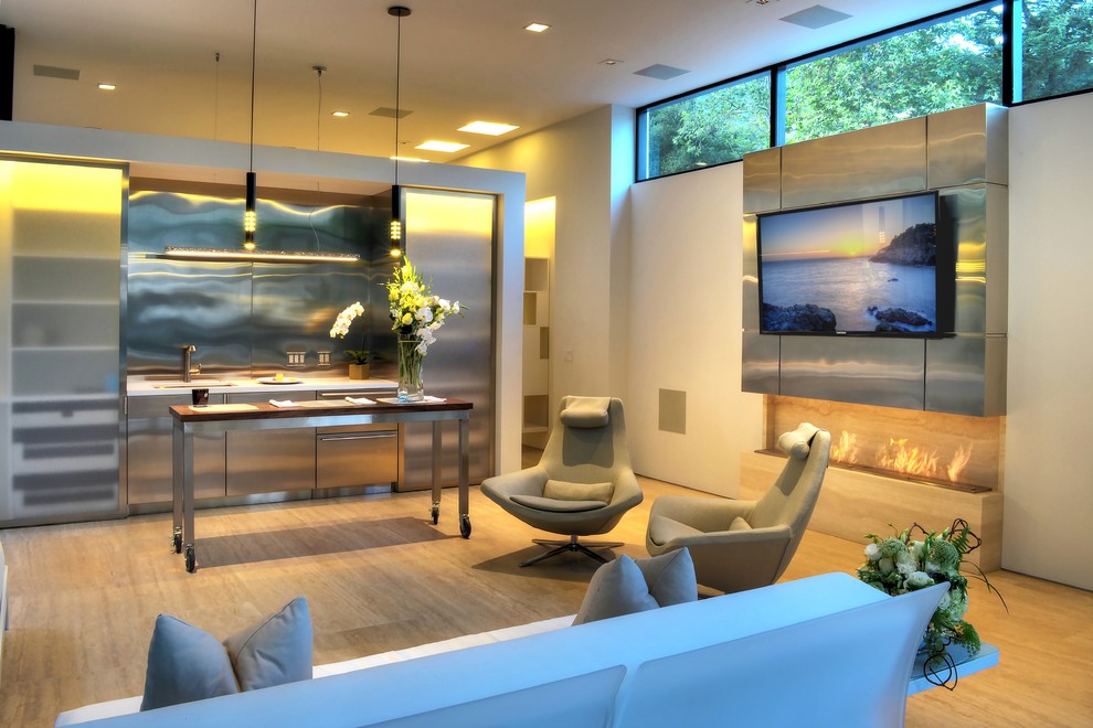 На фото: открытая гостиная комната среднего размера в стиле модернизм с белыми стенами, полом из травертина, горизонтальным камином, фасадом камина из камня и телевизором на стене