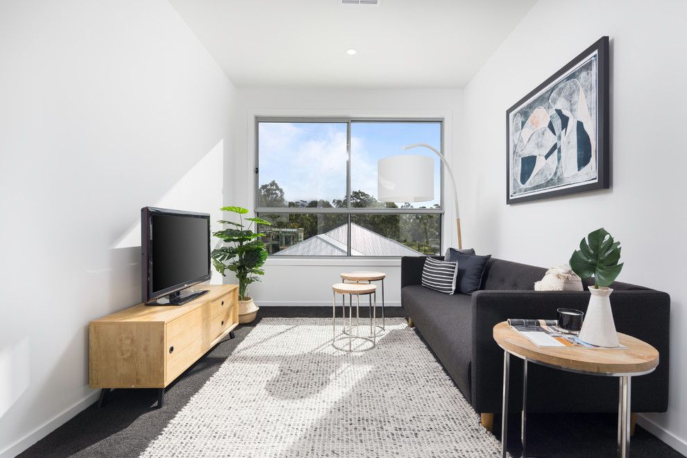 Nordisches Wohnzimmer mit weißer Wandfarbe, Teppichboden, freistehendem TV und schwarzem Boden in Brisbane