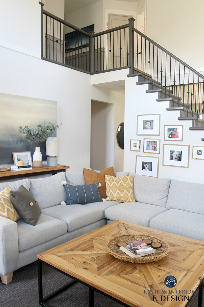 На фото: открытая гостиная комната среднего размера в стиле неоклассика (современная классика) с серыми стенами, паркетным полом среднего тона, стандартным камином, фасадом камина из камня, телевизором на стене и коричневым полом