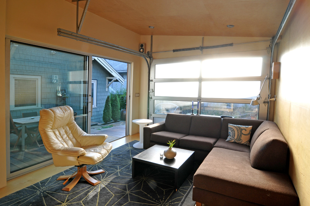 Kleines, Abgetrenntes Modernes Wohnzimmer mit gelber Wandfarbe, Betonboden und gelbem Boden in Seattle