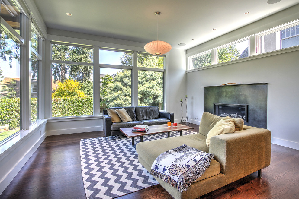 Photo of a medium sized contemporary enclosed living room in Seattle with a music area, white walls, medium hardwood flooring, a standard fireplace and a metal fireplace surround.