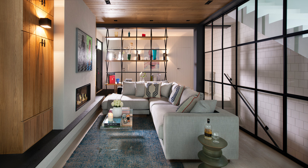 Источник вдохновения для домашнего уюта: гостиная комната в современном стиле с белыми стенами, светлым паркетным полом, стандартным камином и бежевым полом