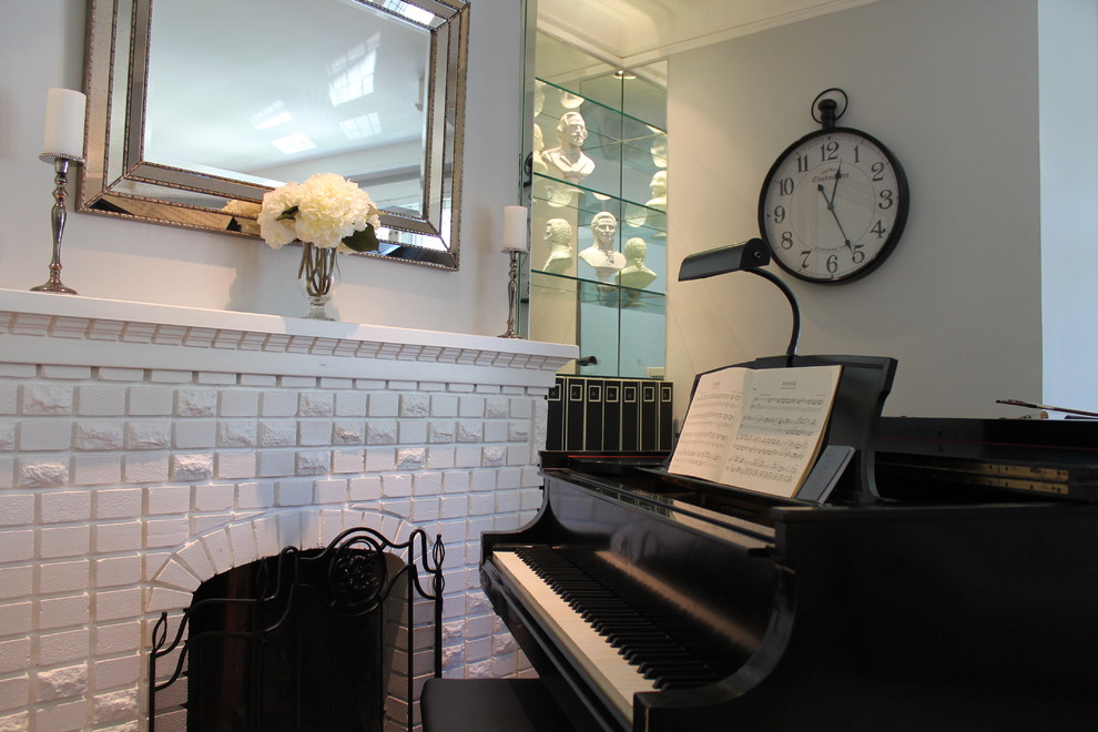 Inspiration for a small transitional enclosed medium tone wood floor living room remodel in Montreal with a music area, blue walls, a standard fireplace, a brick fireplace and no tv