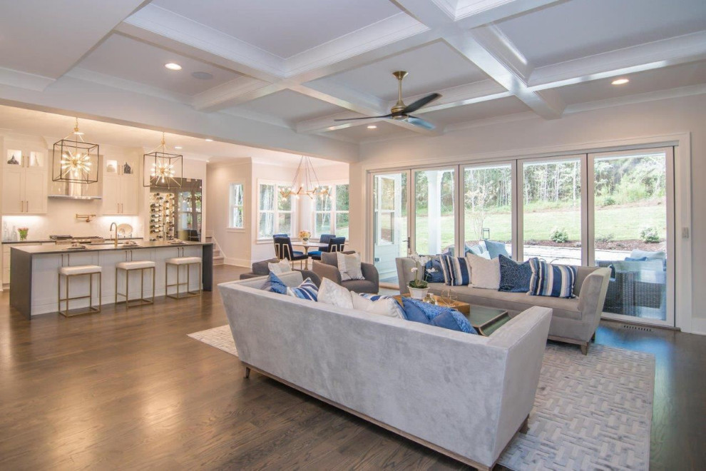 Example of a large trendy open concept brown floor and coffered ceiling living room design in Raleigh with gray walls, a standard fireplace and a wall-mounted tv