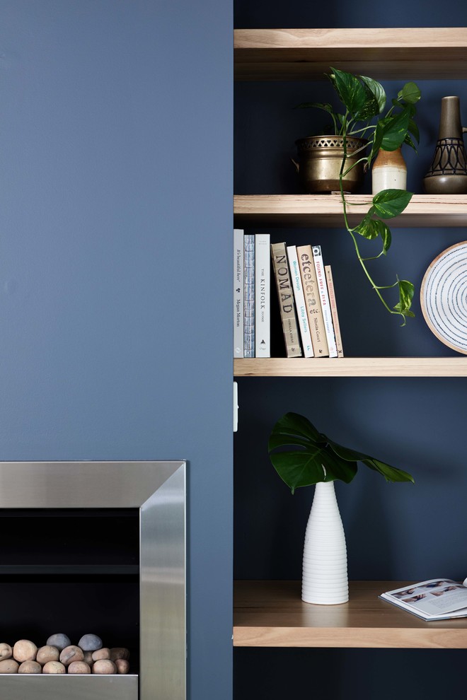 Idéer för minimalistiska allrum med öppen planlösning, med blå väggar, ljust trägolv och en fristående TV