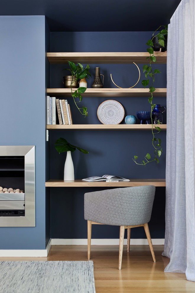 Idee per un soggiorno nordico aperto con pareti blu, parquet chiaro e TV autoportante