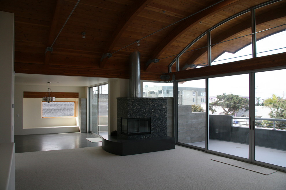 Cette image montre un salon minimaliste de taille moyenne et ouvert avec un mur blanc, un sol en calcaire, une cheminée double-face et un manteau de cheminée en pierre.