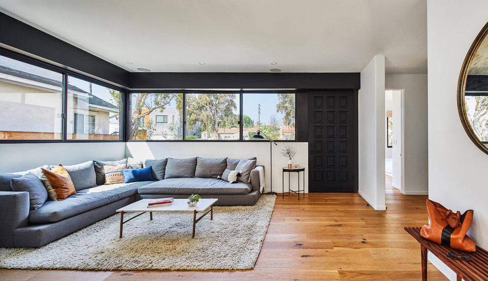 Immagine di un grande soggiorno contemporaneo aperto con pareti bianche, pavimento in legno massello medio e pavimento marrone