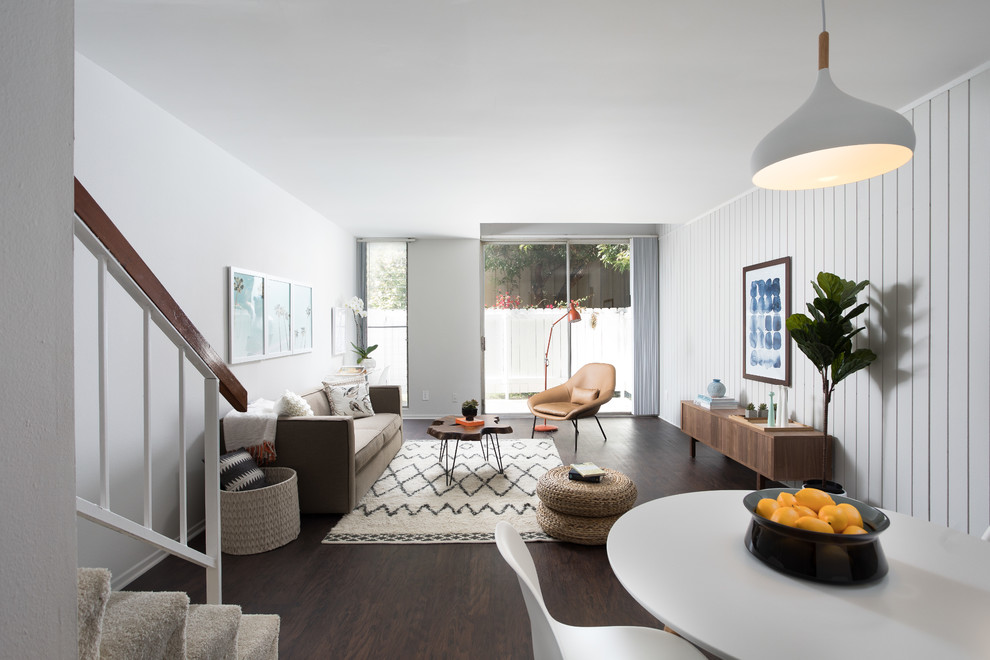 Idee per un soggiorno minimalista con pareti bianche, parquet scuro e pavimento marrone