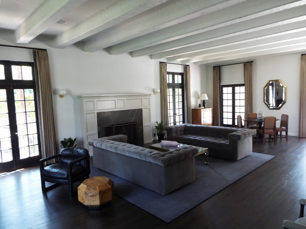 Großes, Repräsentatives, Fernseherloses, Offenes Modernes Wohnzimmer mit weißer Wandfarbe, dunklem Holzboden, Kamin, Kaminumrandung aus Stein und braunem Boden in Los Angeles