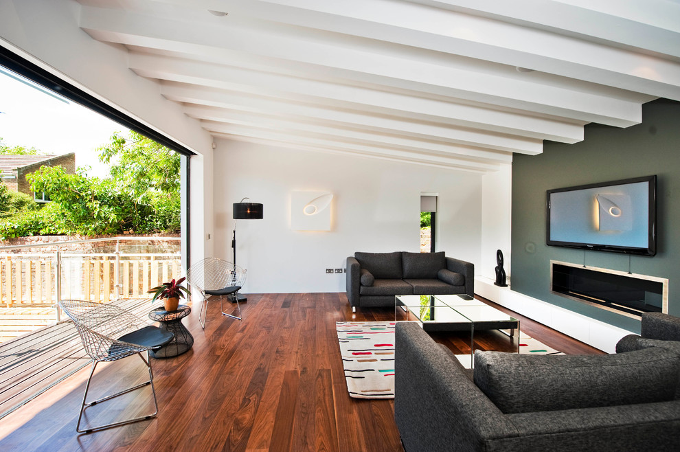 Modelo de salón minimalista con paredes verdes y chimenea lineal