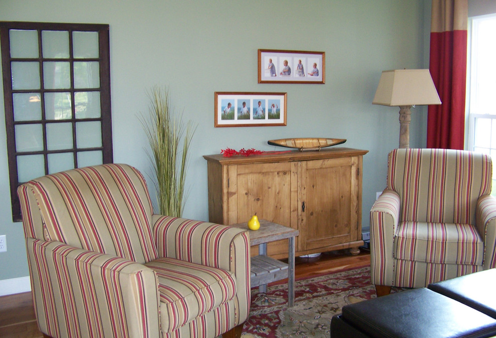 Immagine di un soggiorno classico di medie dimensioni con pareti verdi, parquet chiaro, camino classico e cornice del camino in pietra