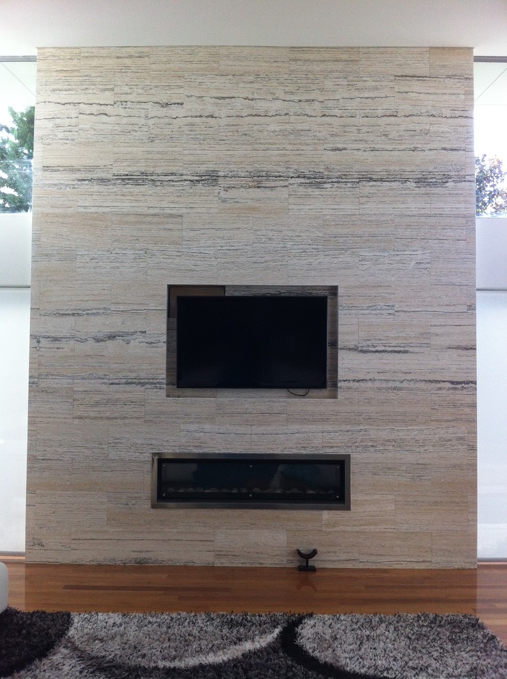 パースにある高級な巨大なコンテンポラリースタイルのおしゃれなLDK (マルチカラーの壁、無垢フローリング、横長型暖炉、石材の暖炉まわり、壁掛け型テレビ) の写真
