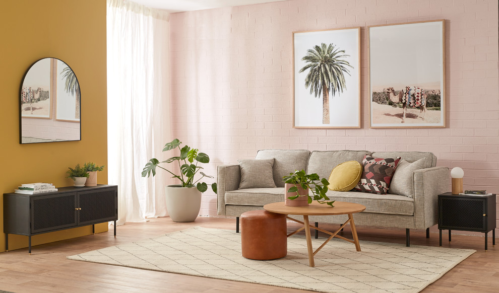 На фото: открытая гостиная комната среднего размера в современном стиле с розовыми стенами, полом из винила и коричневым полом с