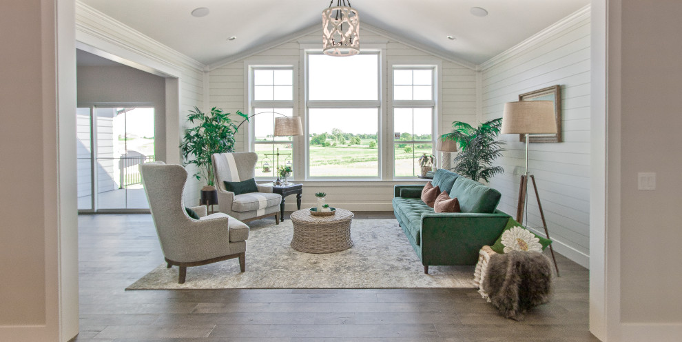 Country formal enclosed living room with medium hardwood flooring, brown floors, a vaulted ceiling and tongue and groove walls.
