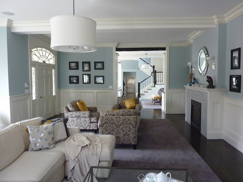 На фото: большая открытая гостиная комната в современном стиле с синими стенами, темным паркетным полом, стандартным камином и фасадом камина из плитки