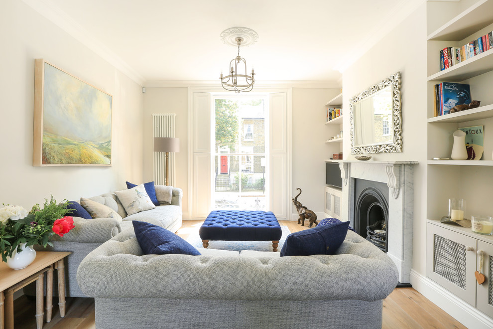 Klassisches Wohnzimmer mit beiger Wandfarbe, braunem Holzboden, Kamin und braunem Boden in London