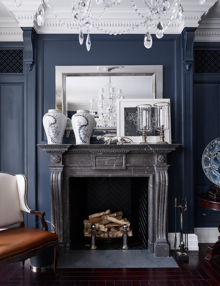 Idée de décoration pour un salon tradition avec un mur bleu, une cheminée standard et un manteau de cheminée en pierre.
