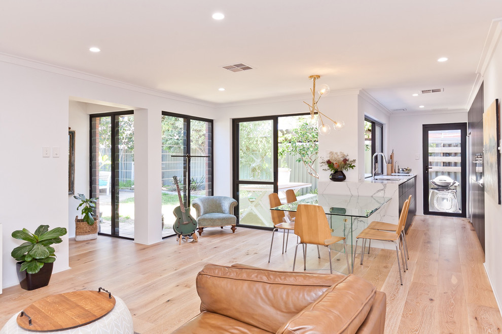 Example of a trendy open concept medium tone wood floor and brown floor living room design in Perth with white walls