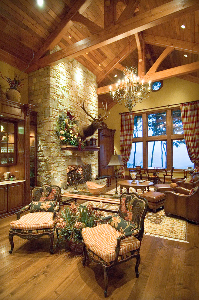 Photo of an expansive rustic open plan living room in Charlotte with a standard fireplace, a stone fireplace surround and no tv.