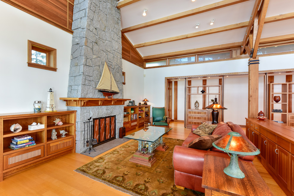 Maritimes Wohnzimmer mit weißer Wandfarbe, braunem Holzboden, Kamin und Kaminumrandung aus Stein in Seattle