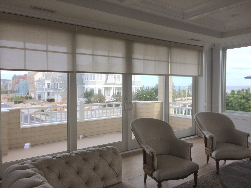 Idee per un soggiorno stile marino aperto con pareti beige, parquet chiaro e parete attrezzata