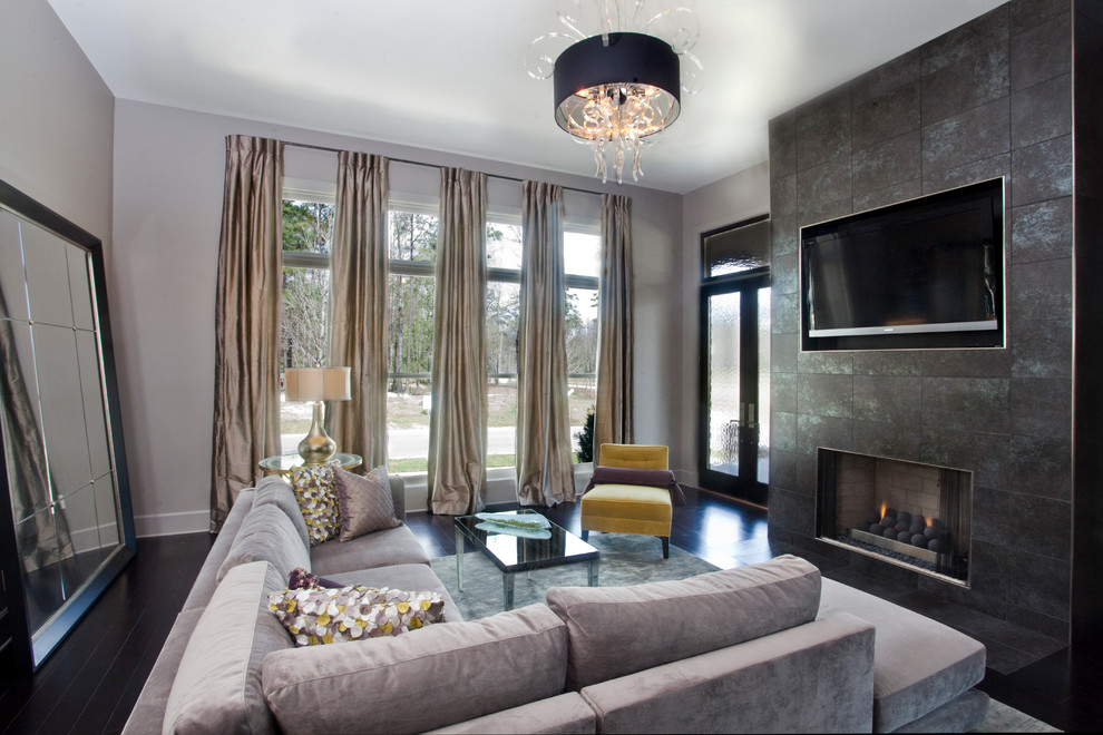 На фото: гостиная комната:: освещение в современном стиле с фасадом камина из плитки, черным полом и ковром на полу