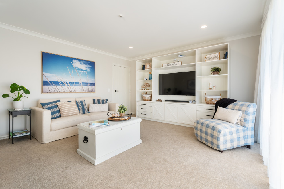 Источник вдохновения для домашнего уюта: изолированная гостиная комната среднего размера в морском стиле с бежевыми стенами, ковровым покрытием, телевизором на стене и бежевым полом