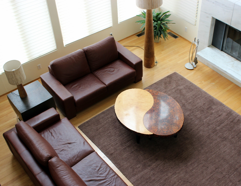 Immagine di un soggiorno moderno aperto con pareti bianche, parquet chiaro, stufa a legna e cornice del camino in pietra