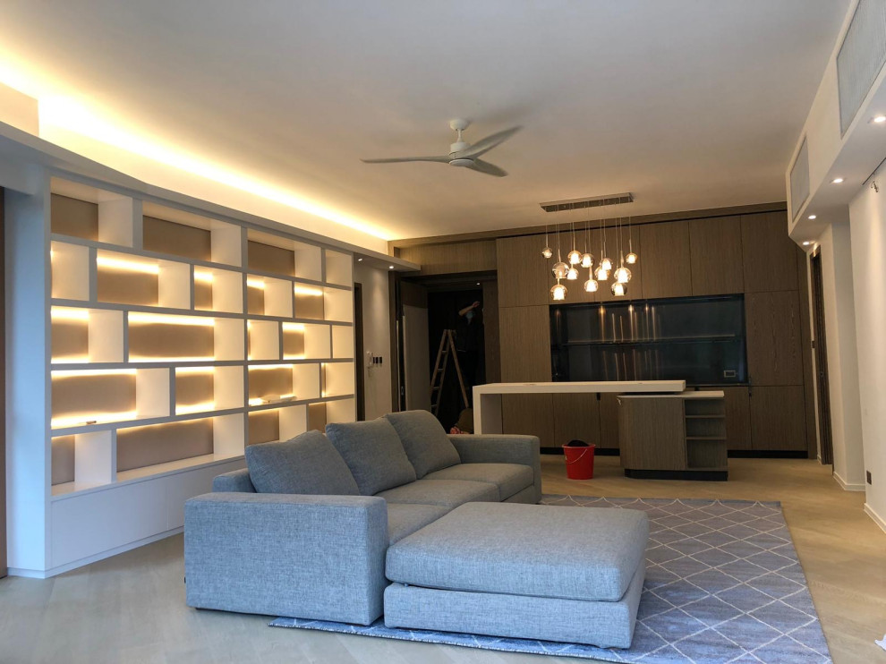 Cette photo montre un salon moderne de taille moyenne avec une bibliothèque ou un coin lecture, un mur beige et un téléviseur fixé au mur.