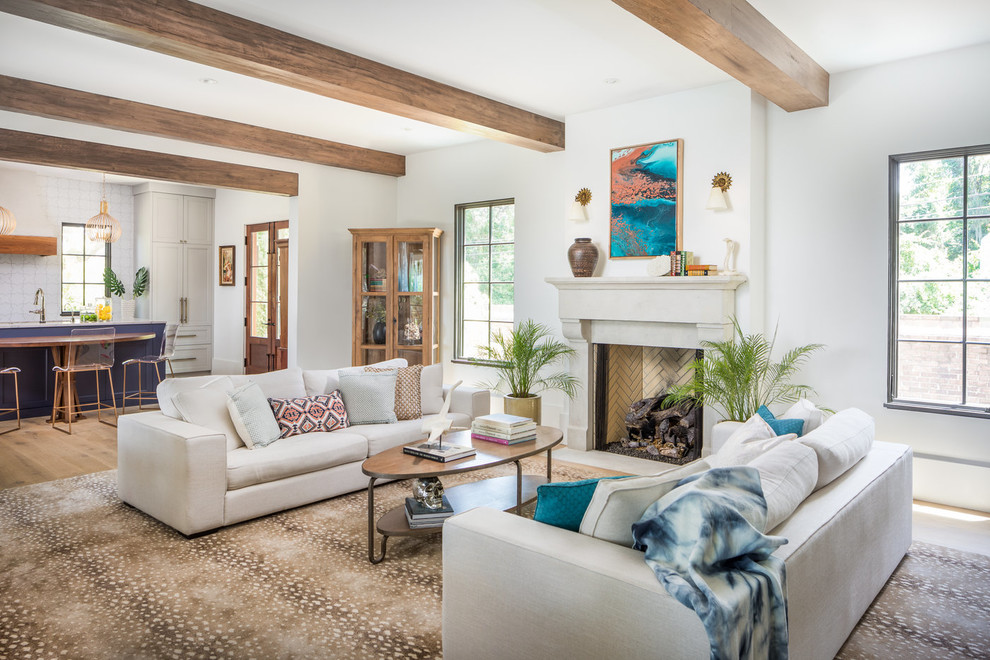 Mediterranes Wohnzimmer mit weißer Wandfarbe, braunem Holzboden, Kamin und braunem Boden in Charleston