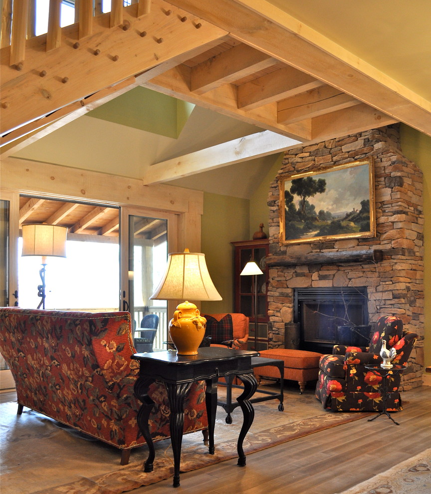 Aménagement d'un salon montagne de taille moyenne et ouvert avec une salle de réception, un mur vert, un sol en bois brun, une cheminée standard, un manteau de cheminée en pierre et aucun téléviseur.