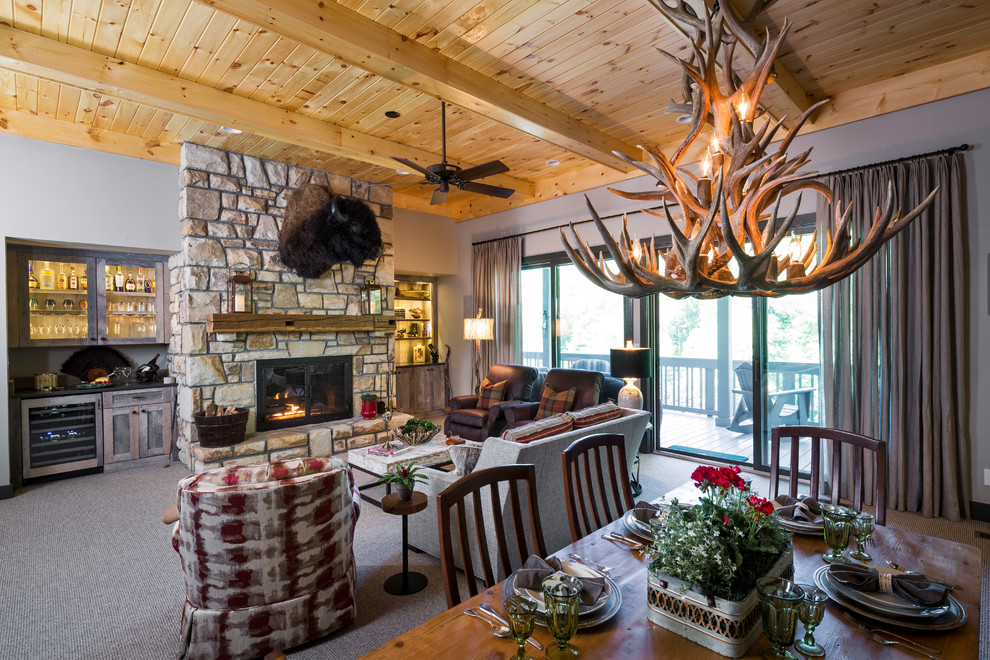 Photo of a large rustic open plan living room in Charlotte with beige walls, carpet, a standard fireplace, a stone fireplace surround, a home bar, no tv and grey floors.